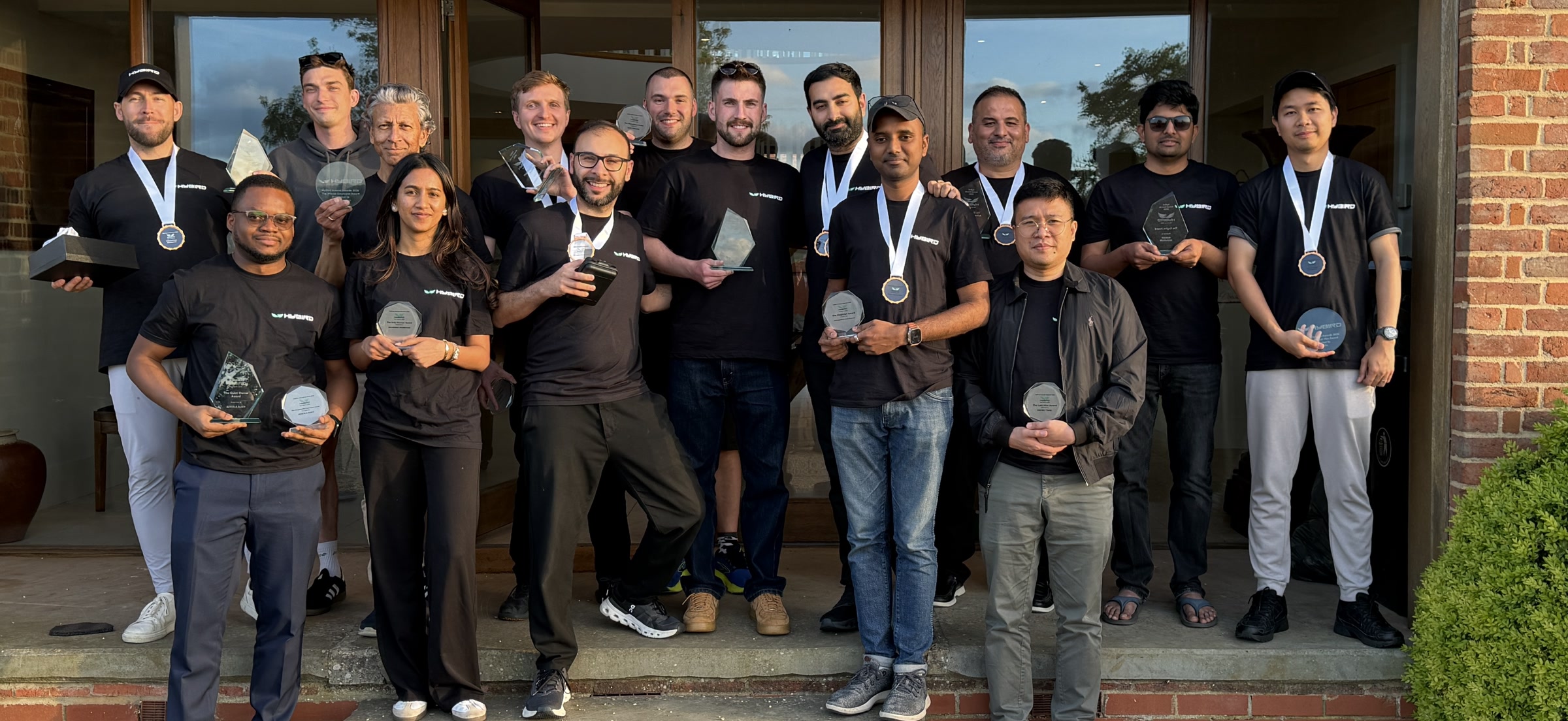 The HyBird team gathered together, holding awards and wearing HyBird shirts