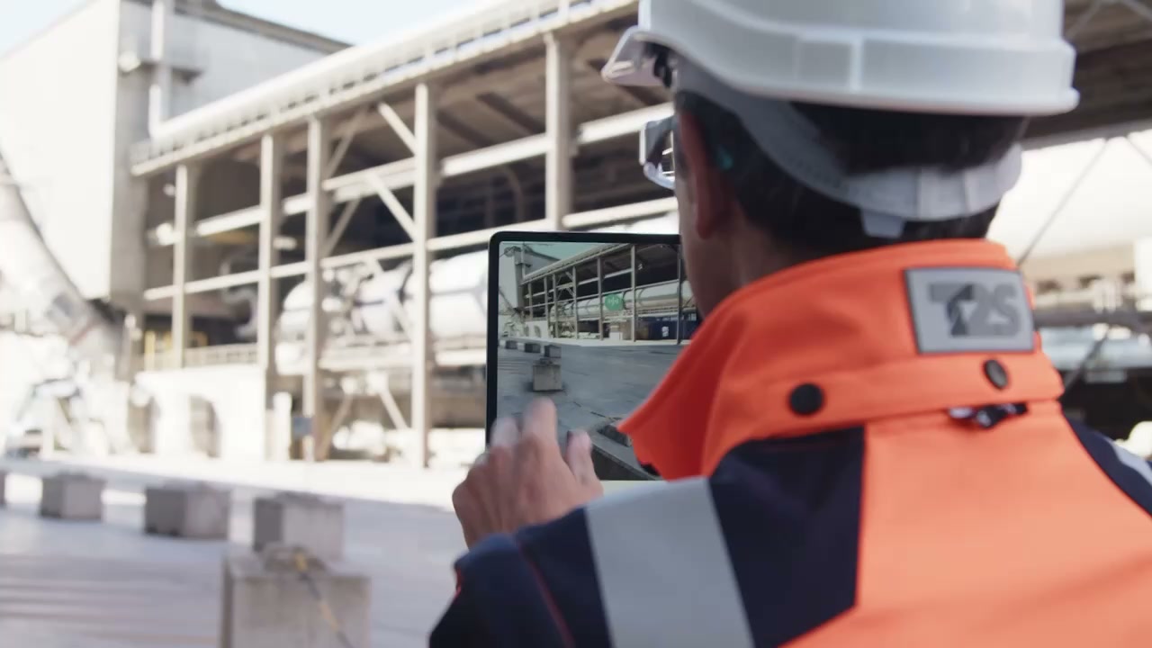 An operator using connected plant information on a tablet in the field