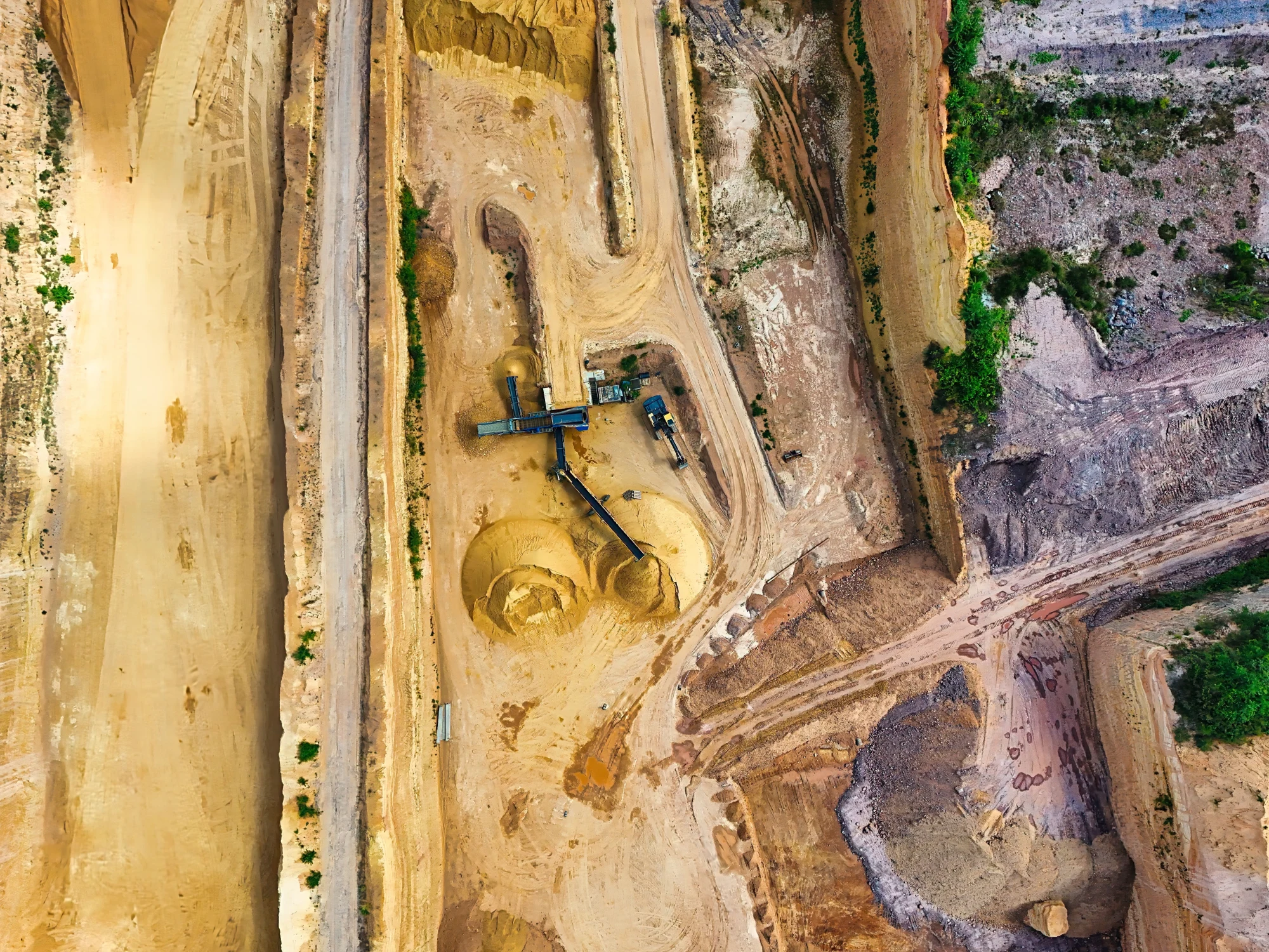 Aerial view of an open-pit mine with excavated benches and haul roads